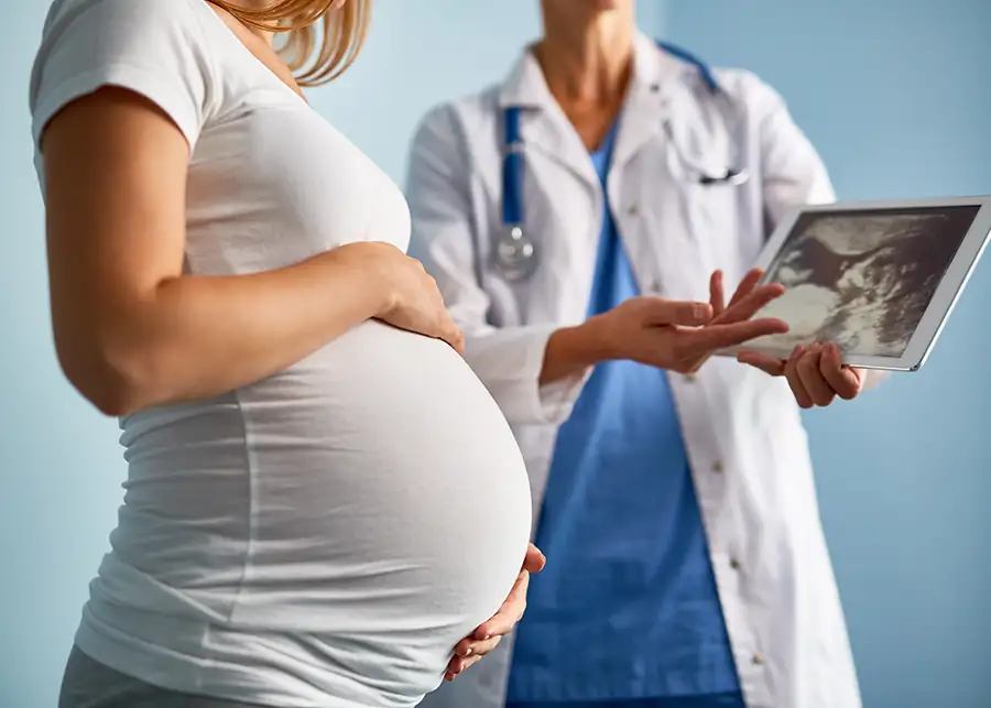 Pregnant young woman at the doctor's office, referencing ultrasound, diagnostic services - Centralia, IL